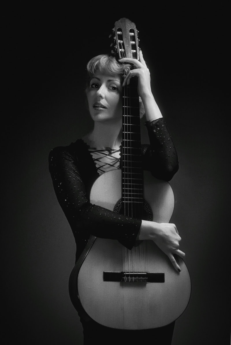 professional headshot of a musician holding her guitar