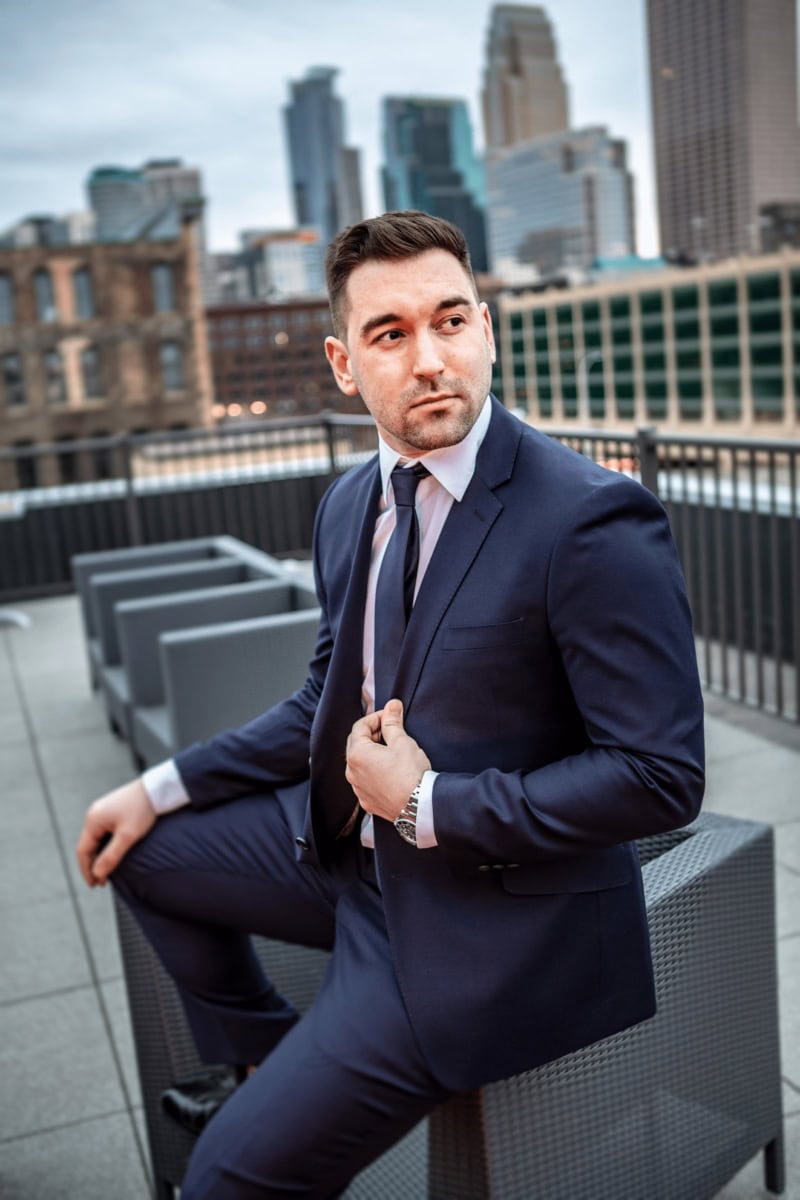 man in formal wear taking professional outdoor headshots with buildings